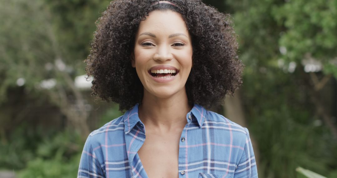 Smiling Woman with Curly Hair Outdoors - Free Images, Stock Photos and Pictures on Pikwizard.com