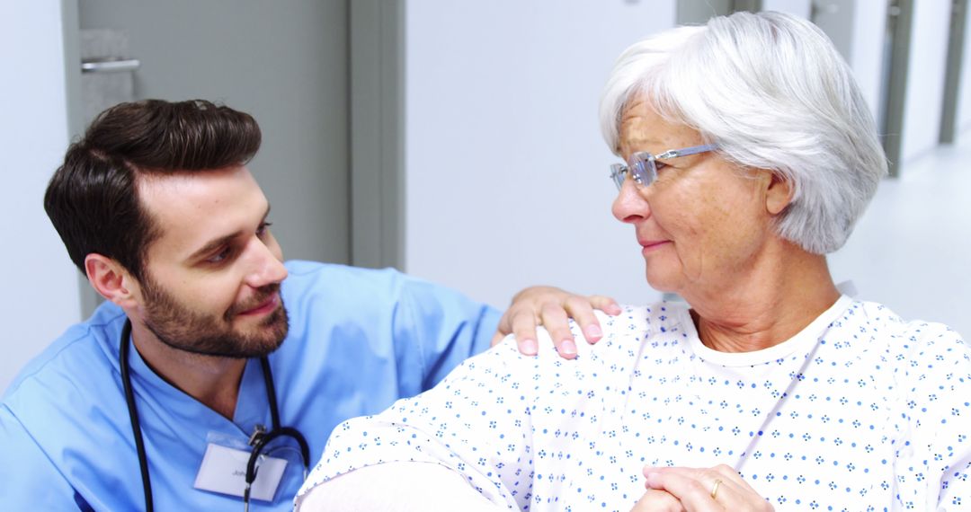 Male Nurse Comforting Elderly Female Patient in Hospital Corridor - Free Images, Stock Photos and Pictures on Pikwizard.com