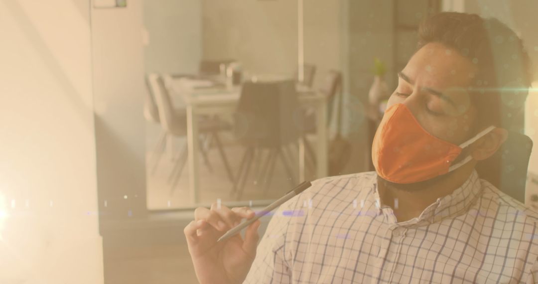 Man Wearing Face Mask Working in Office with Glowing Lights