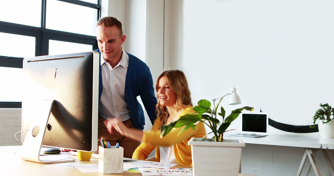 Collaborative Business Team Discussing Work at Computer Desk