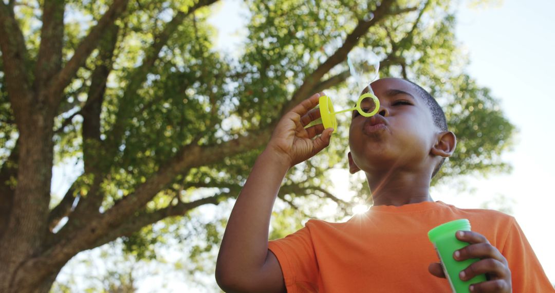 Young Boy Blowing Bubbles Outdoors on Sunny Day - Free Images, Stock Photos and Pictures on Pikwizard.com