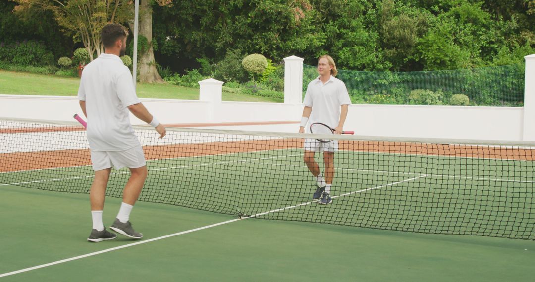 Two Men Playing Tennis on Outdoor Court - Free Images, Stock Photos and Pictures on Pikwizard.com