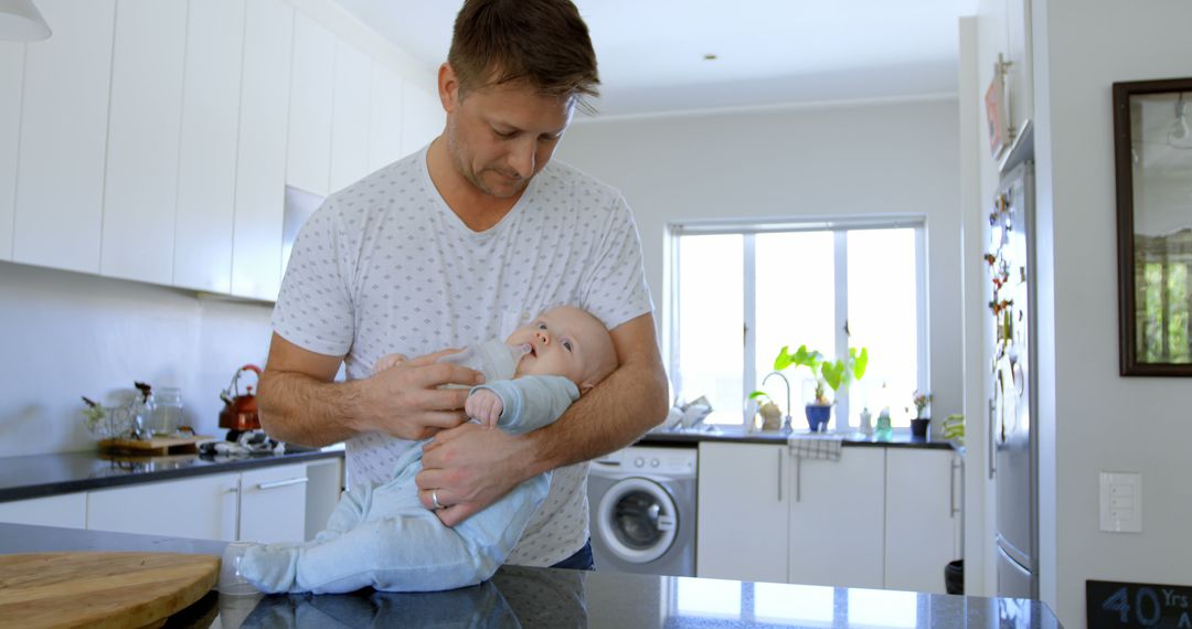 Father Feeding Baby Bottle in Modern Kitchen - Free Images, Stock Photos and Pictures on Pikwizard.com