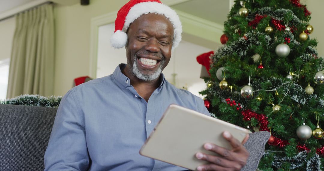 Happy senior african american man using tablet at christmas - Free Images, Stock Photos and Pictures on Pikwizard.com