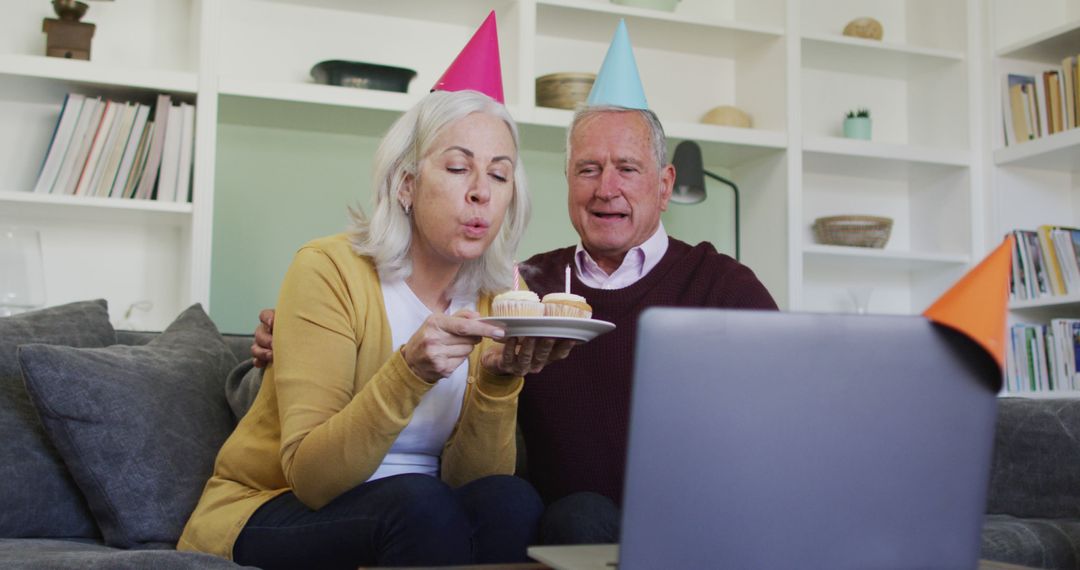 Senior Couple Celebrating Birthday via Video Call with Cake and Hats - Free Images, Stock Photos and Pictures on Pikwizard.com