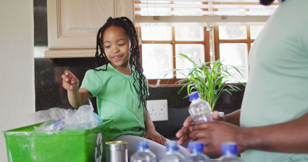 Father and Daughter in Kitchen Sorting Recycling