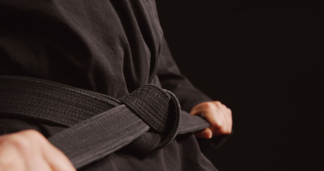 Close-up of Martial Artist Tying Black Belt - Free Images, Stock Photos and Pictures on Pikwizard.com