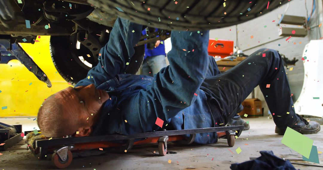 Mechanic Using Creeper Inspecting Vehicle Underbelly with Particles