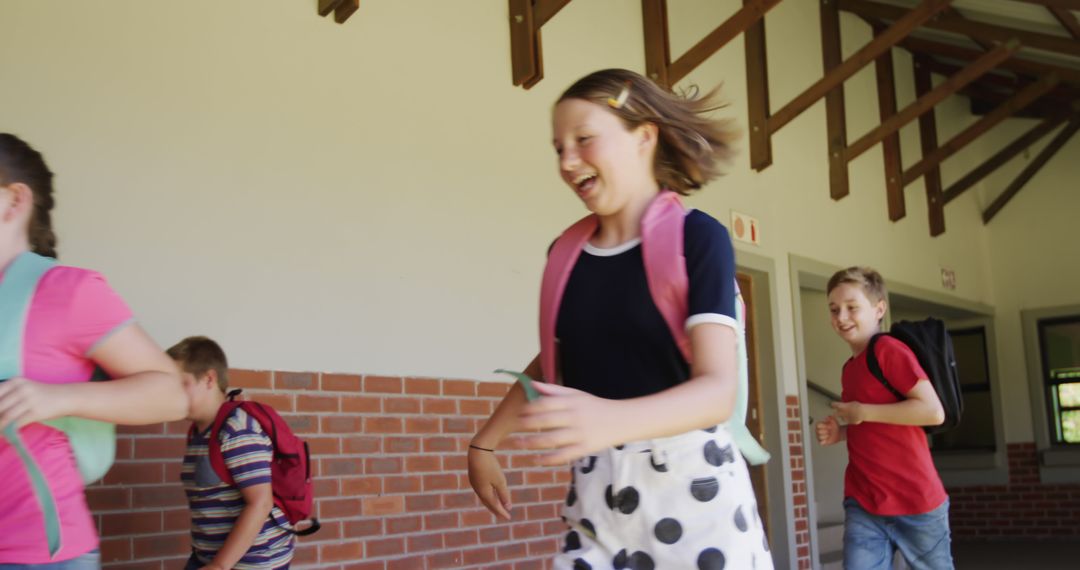 Joyful Children Running in School Corridor with Backpacks