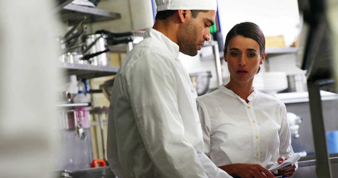 Chef Collaborating with Waitress in Professional Kitchen