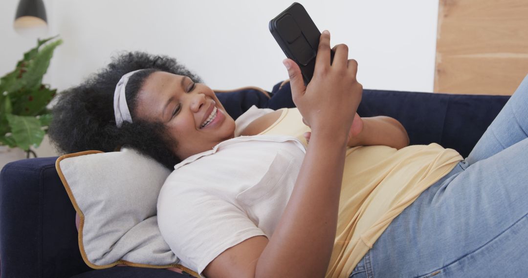 Smiling Woman Relaxing on Couch Using Smartphone - Free Images, Stock Photos and Pictures on Pikwizard.com