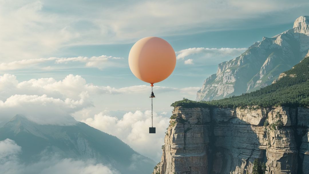 Peach Balloon Hovering Over Majestic Mountain Cliff