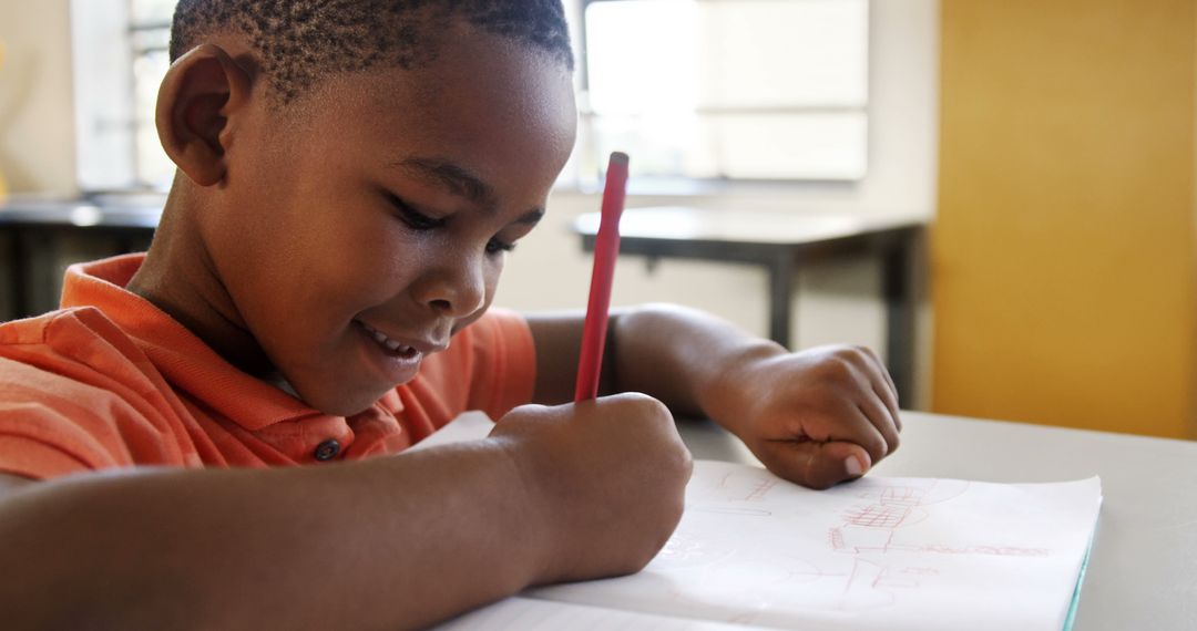 African American Boy Smiling While Drawing in Classroom - Free Images, Stock Photos and Pictures on Pikwizard.com