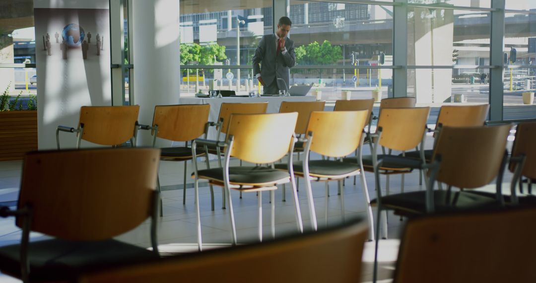 Businessman Preparing for Conference in Modern Sunlit Room - Free Images, Stock Photos and Pictures on Pikwizard.com