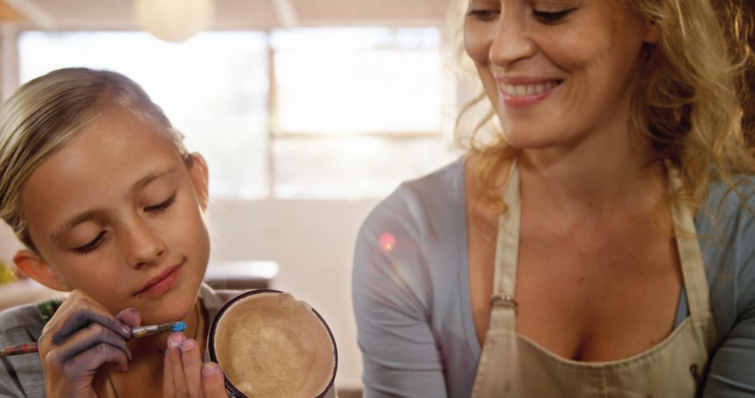 Woman and Girl Smiling While Painting Pottery Together Indoors - Free Images, Stock Photos and Pictures on Pikwizard.com