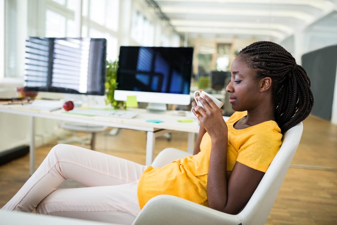 Female Graphic Designer Relaxing with Coffee in Modern Office - Free Images, Stock Photos and Pictures on Pikwizard.com