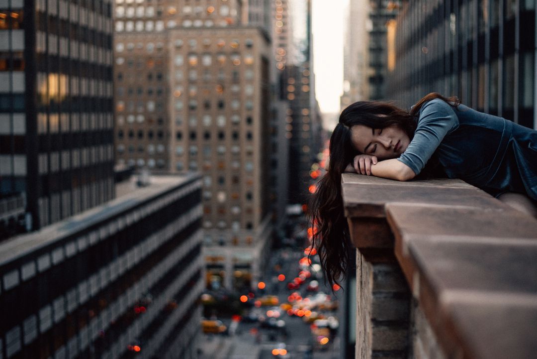 Young woman resting on city balcony at sunset - Free Images, Stock Photos and Pictures on Pikwizard.com