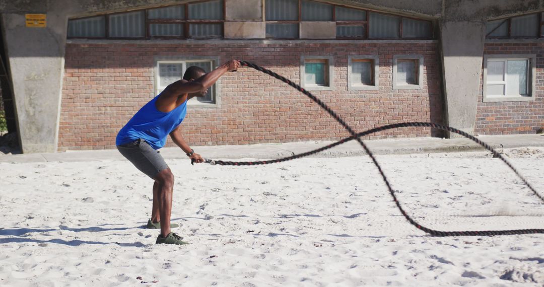 Man Training with Battle Ropes on Beach - Free Images, Stock Photos and Pictures on Pikwizard.com