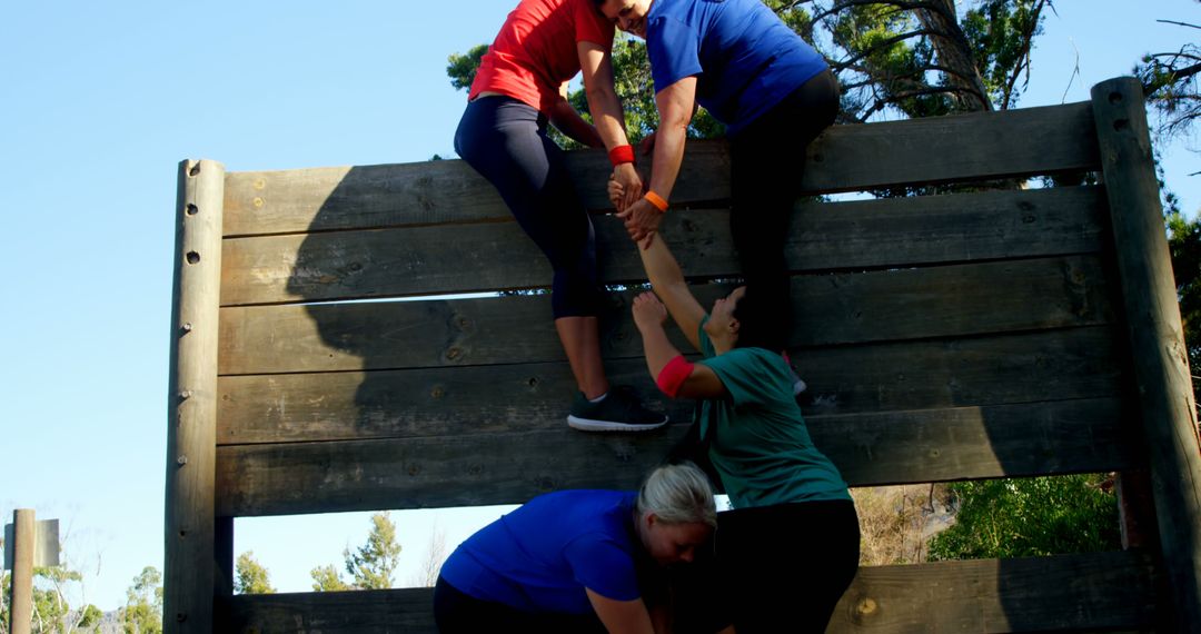 Group Overcoming Obstacle Climbing Wooden Wall in Team Building Exercise - Free Images, Stock Photos and Pictures on Pikwizard.com