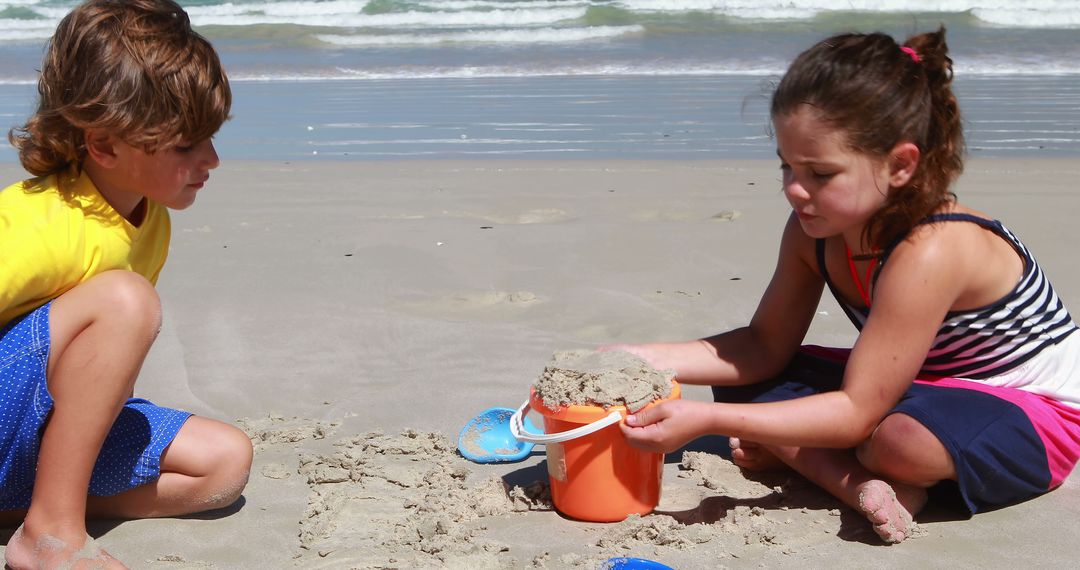 Children Building Sandcastle on Beach Together - Free Images, Stock Photos and Pictures on Pikwizard.com