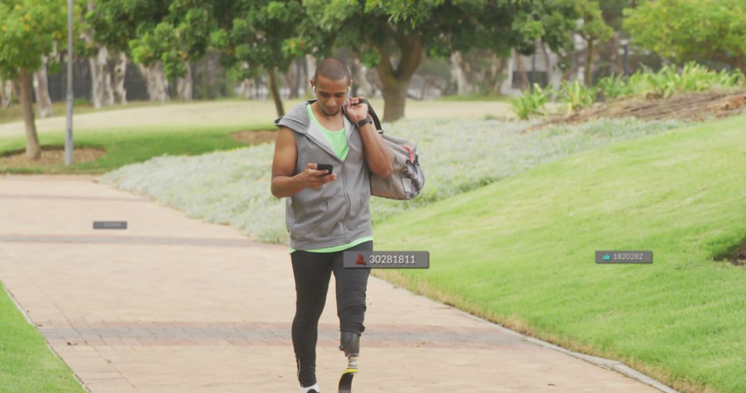 Athletic Man with Prosthetic Leg Walking in Park and Checking Phone - Free Images, Stock Photos and Pictures on Pikwizard.com