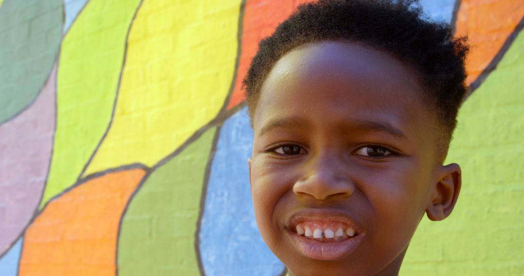 Smiling Schoolboy in Front of Colorful Mural