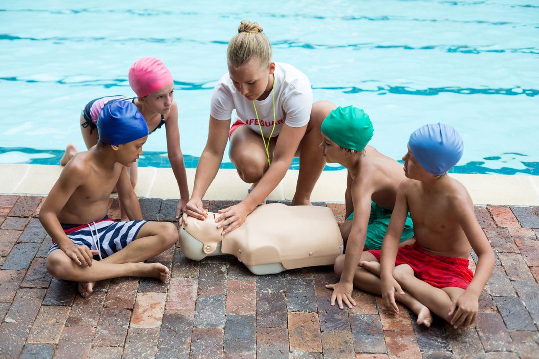 Female Lifeguard Teaching CPR to Children by Poolside - Free Images, Stock Photos and Pictures on Pikwizard.com