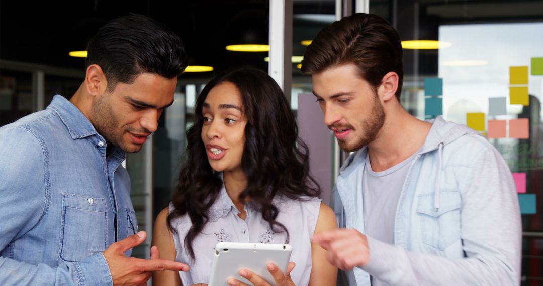 Young Professionals Collaborating over Digital Tablet in Office