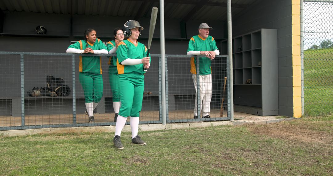 Diverse Softball Team Preparing for Game in Dugout