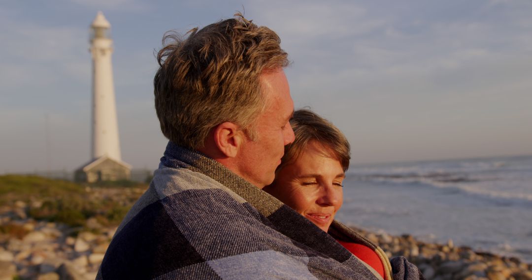 Romantic Couple Embracing Near Lighthouse During Sunset - Free Images, Stock Photos and Pictures on Pikwizard.com