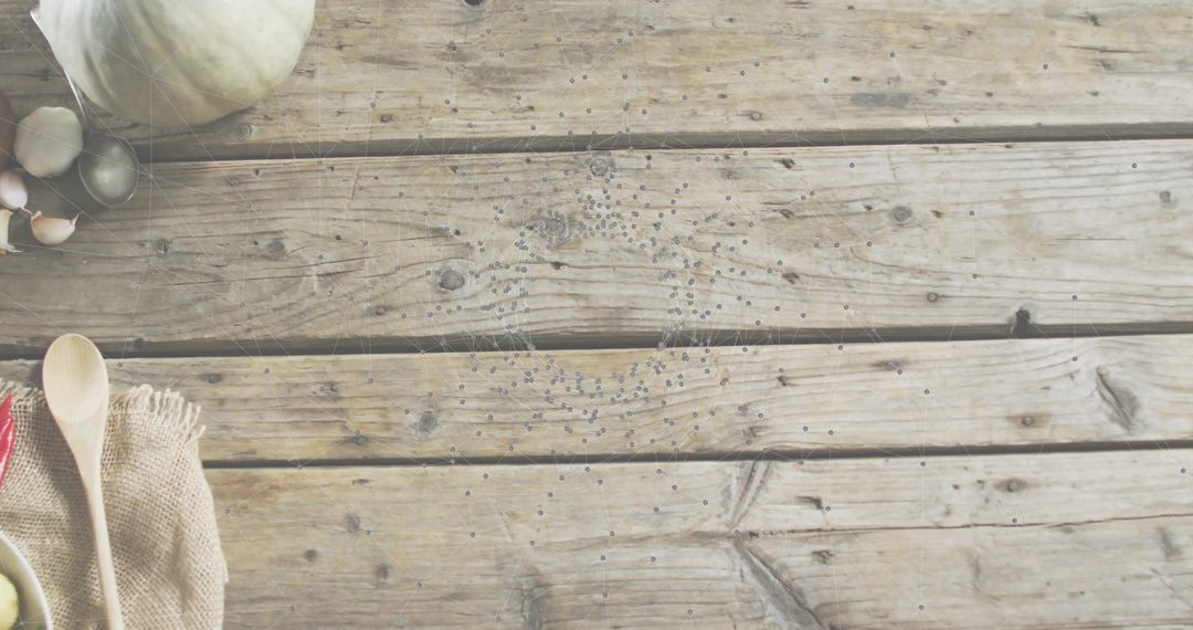 Rustic wooden tabletop showcasing spoons, garlic, olives and gourd with copy space