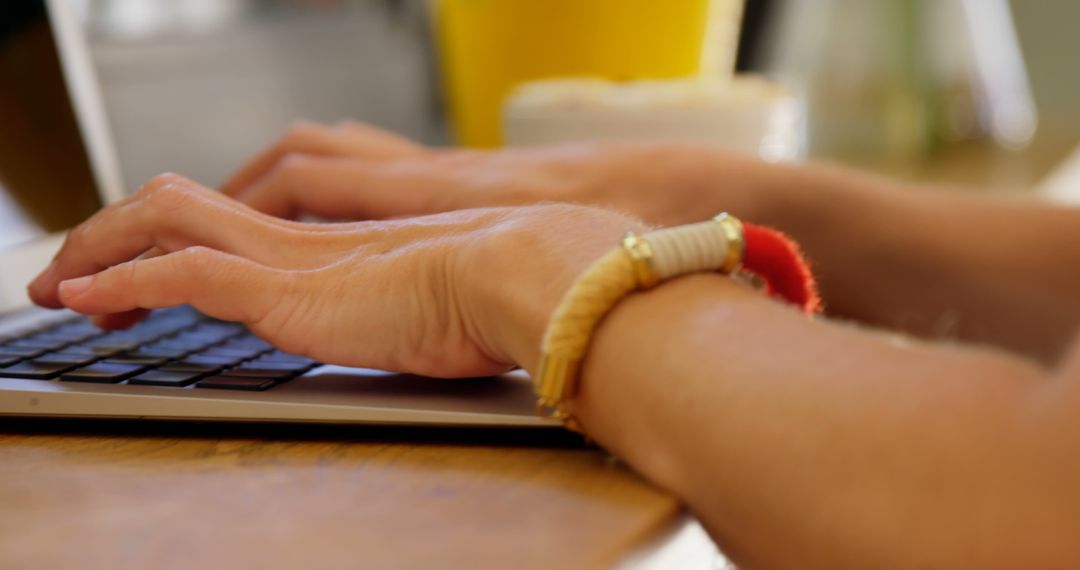 Close-up of Woman Typing on Laptop with Bracelet on Wrist - Free Images, Stock Photos and Pictures on Pikwizard.com