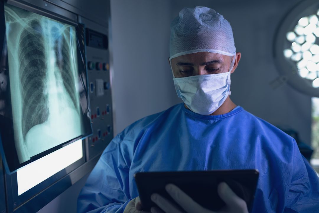 Surgeon Reviewing X-Ray on Digital Tablet in Operating Room - Free Images, Stock Photos and Pictures on Pikwizard.com