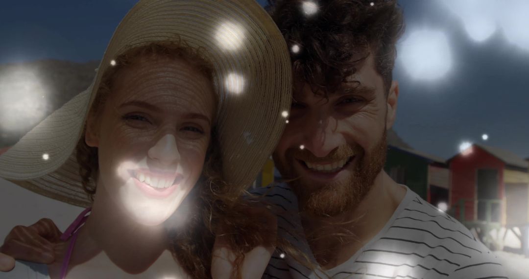 Smiling Couple at Beach with Sunhat and Colorful Huts