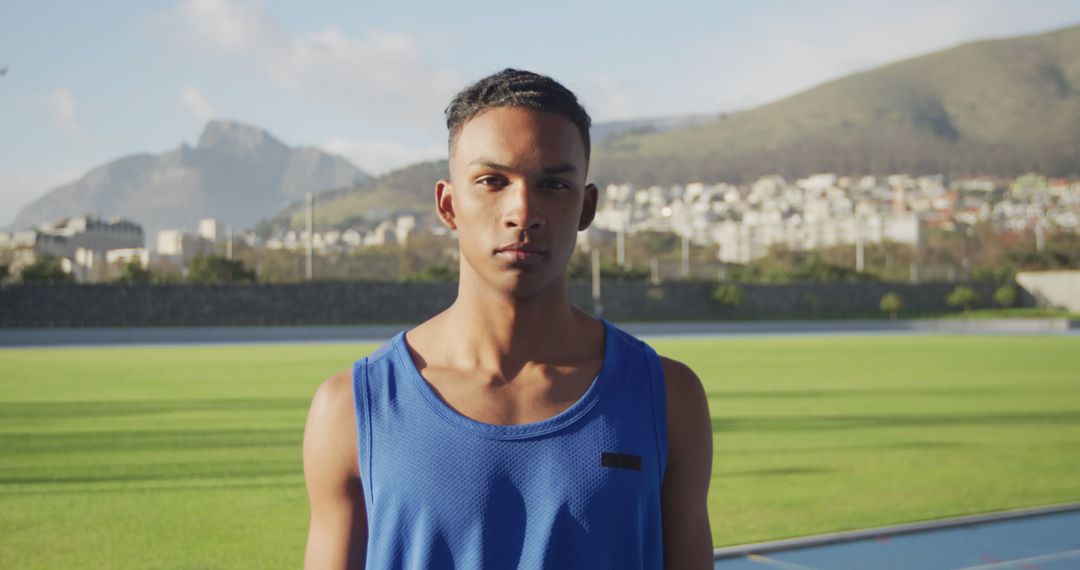 Confident Young Athlete on Sports Field with Mountains in Background - Free Images, Stock Photos and Pictures on Pikwizard.com