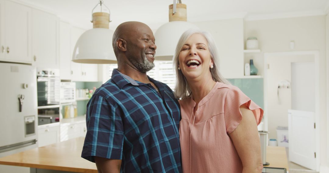 Happy Senior Couple Laughing in Modern Kitchen - Free Images, Stock Photos and Pictures on Pikwizard.com