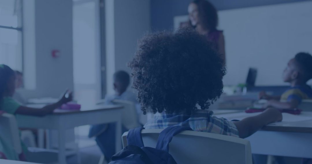 Student with Backpack in Classroom Listening to Teacher