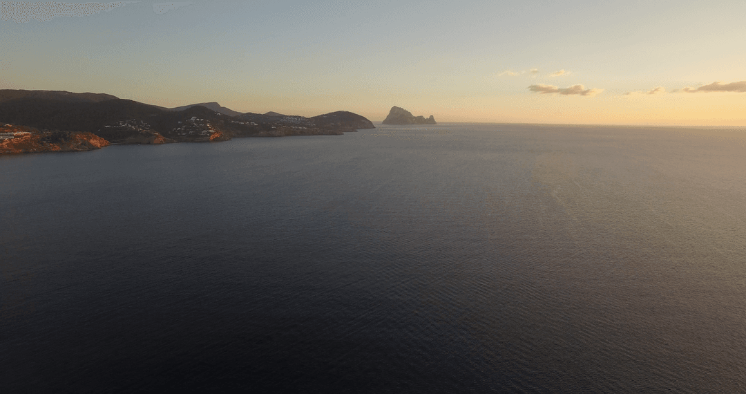 Serene Sunset Over Tranquil Ocean with Distant Land