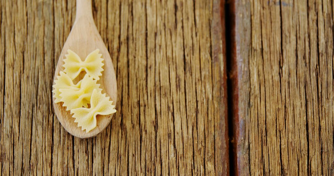 Wooden Spoon with Bowtie Pasta on Rustic Wooden Table - Free Images, Stock Photos and Pictures on Pikwizard.com