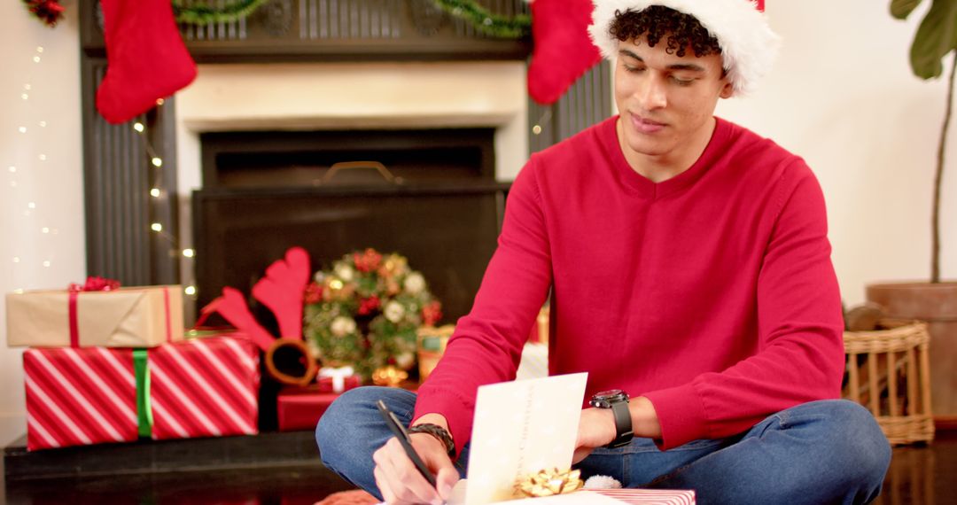 Young Man Writing Christmas Cards by Fireplace - Free Images, Stock Photos and Pictures on Pikwizard.com