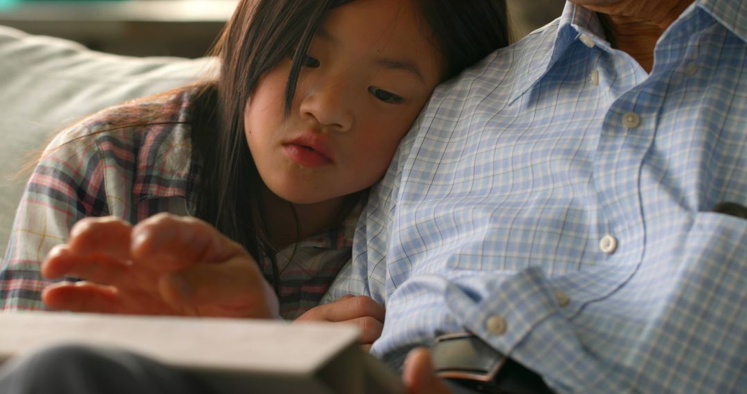 Granddaughter Reading with Grandfather on Couch - Free Images, Stock Photos and Pictures on Pikwizard.com