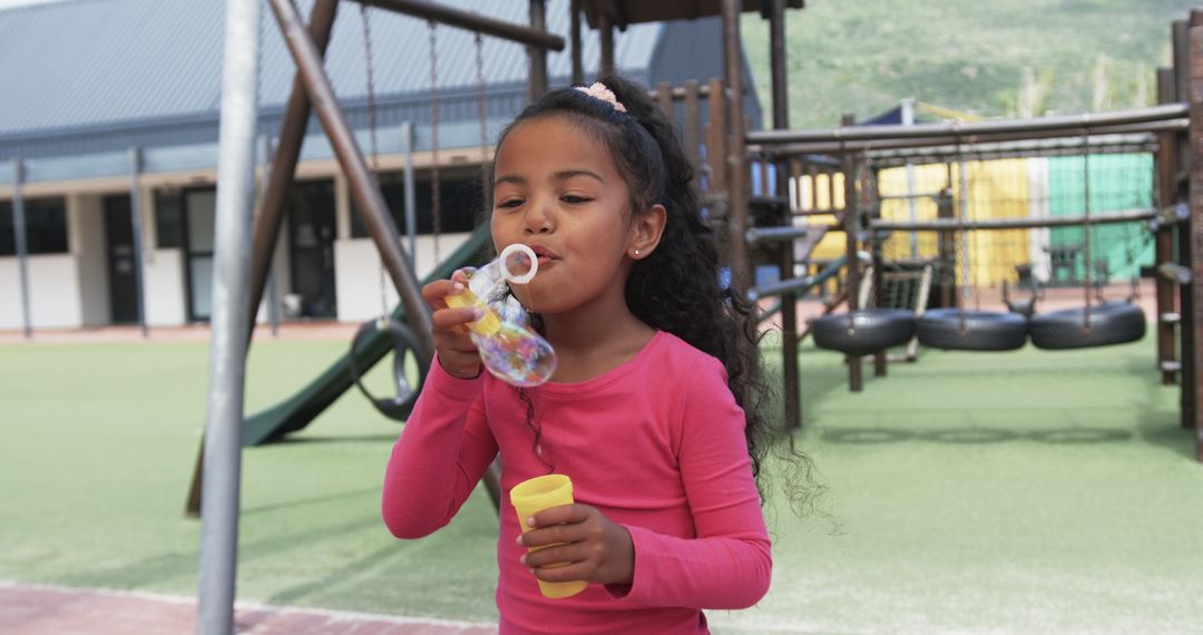 Young Girl Enjoying Making Bubbles in Playground