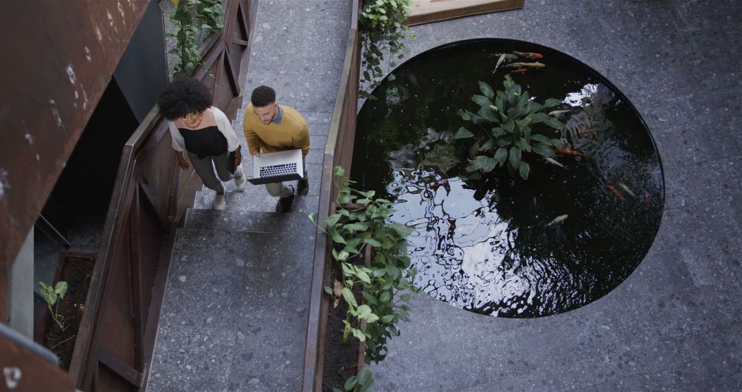 Colleagues Walking Up Stairs in Modern Office Atrium