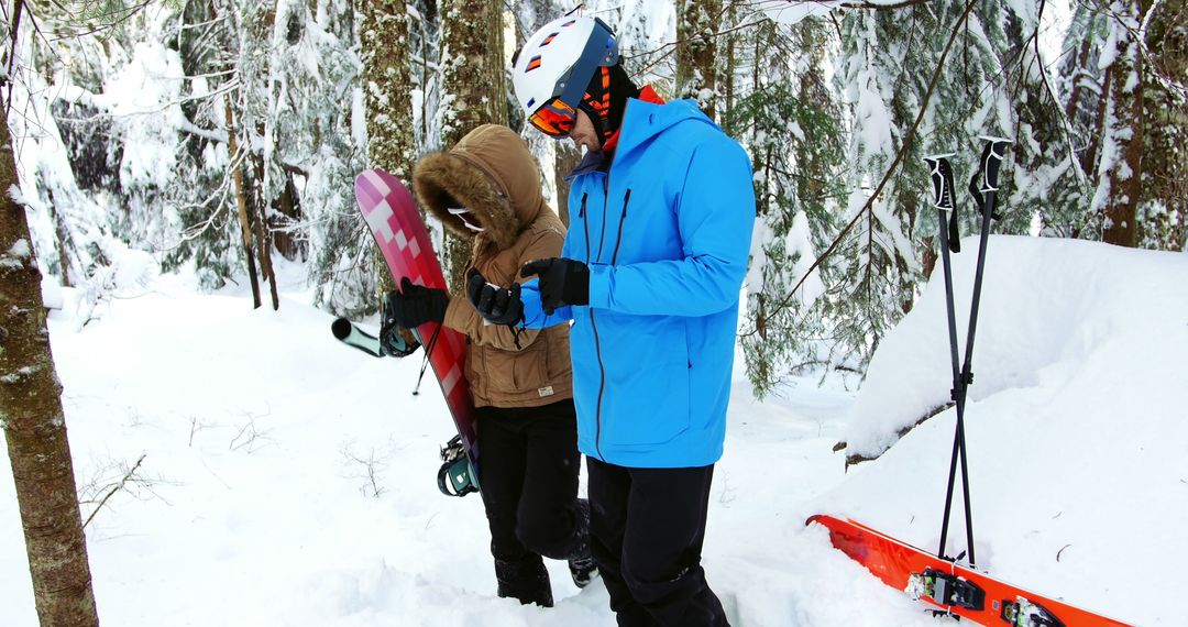 Two people, friends or a couple, are preparing for snowboarding in a snowy forest, with copy space - Free Images, Stock Photos and Pictures on Pikwizard.com