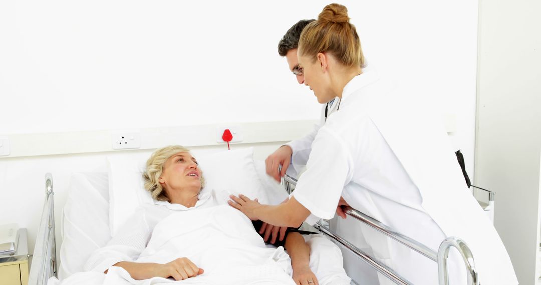 Nurse and Doctor Assisting Elderly Woman in Hospital Bed - Free Images, Stock Photos and Pictures on Pikwizard.com