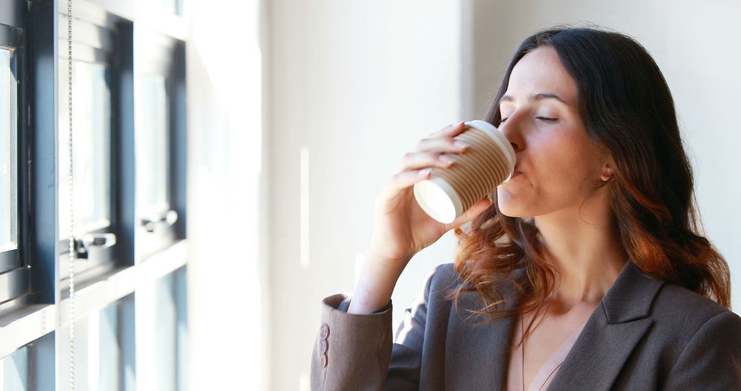 Young Professional Woman Drinking Coffee by Window - Free Images, Stock Photos and Pictures on Pikwizard.com