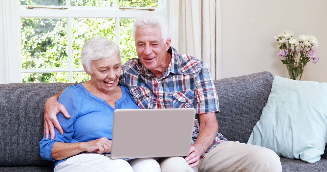 Senior Couple Using Laptop Together on Sofa at Home - Free Images, Stock Photos and Pictures on Pikwizard.com