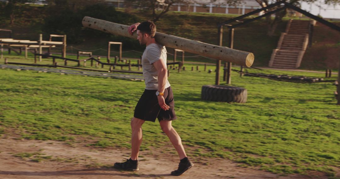 Man Carrying Heavy Log Outdoors for Intense Workout