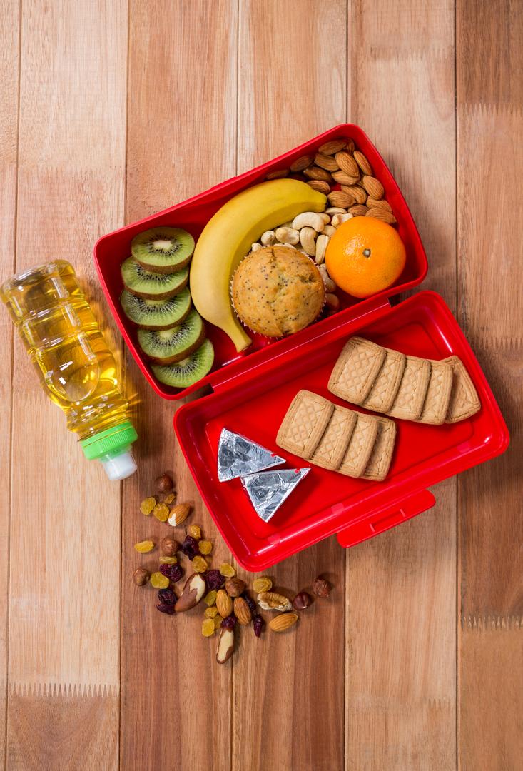 Healthy Lunchbox with Fruits, Nuts, and Snacks on Wooden Table - Free Images, Stock Photos and Pictures on Pikwizard.com