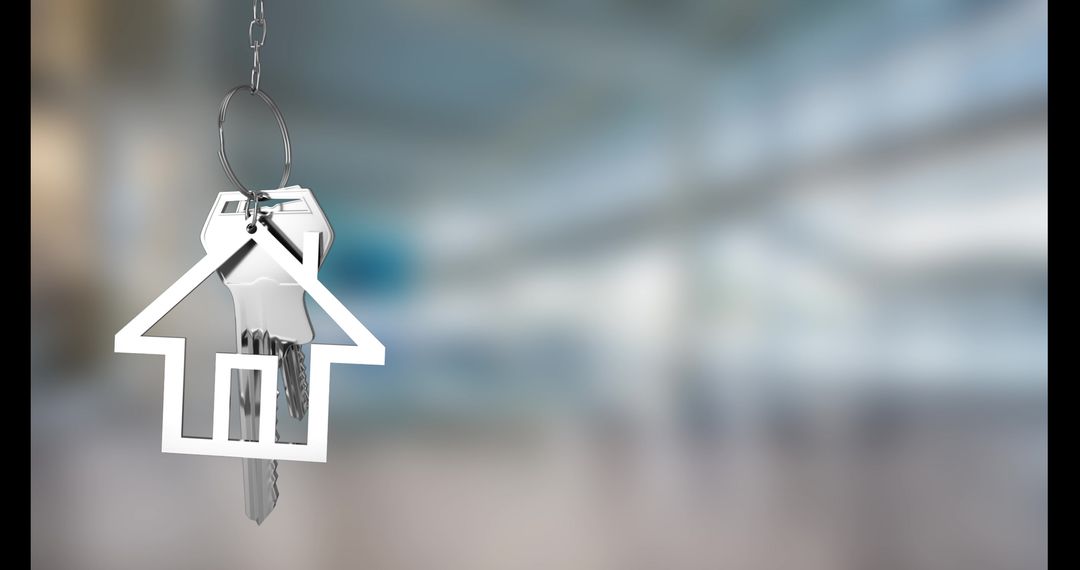 Silver House Keychain Symbolizing New Home against Blurred Background